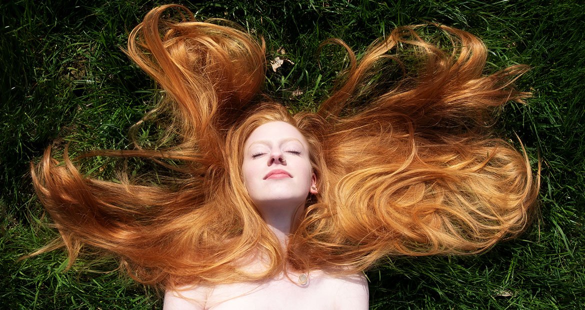 Pessoa com cabelo ruivo cobre deitada